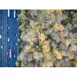 Photo from above showing 12 lane highway and trees of the park