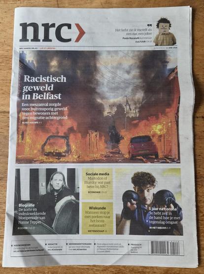 Front page of NRC newspaper with that headline and photo of burning street in Belfast