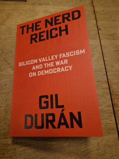 Photo of the cover. Red with black title in all caps.