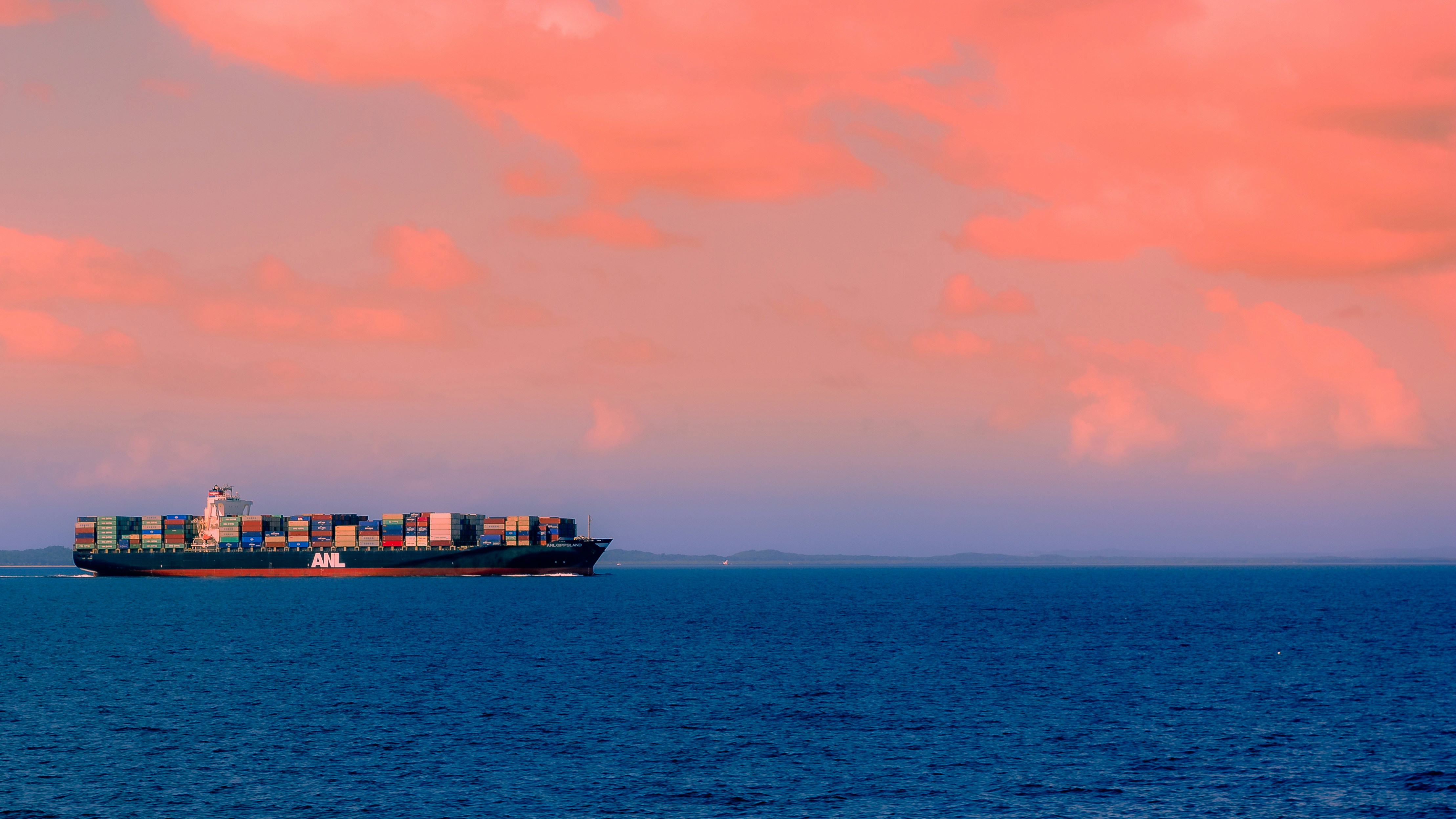 Buque de carga en el horizonte con trayectoria izquierda a derecha