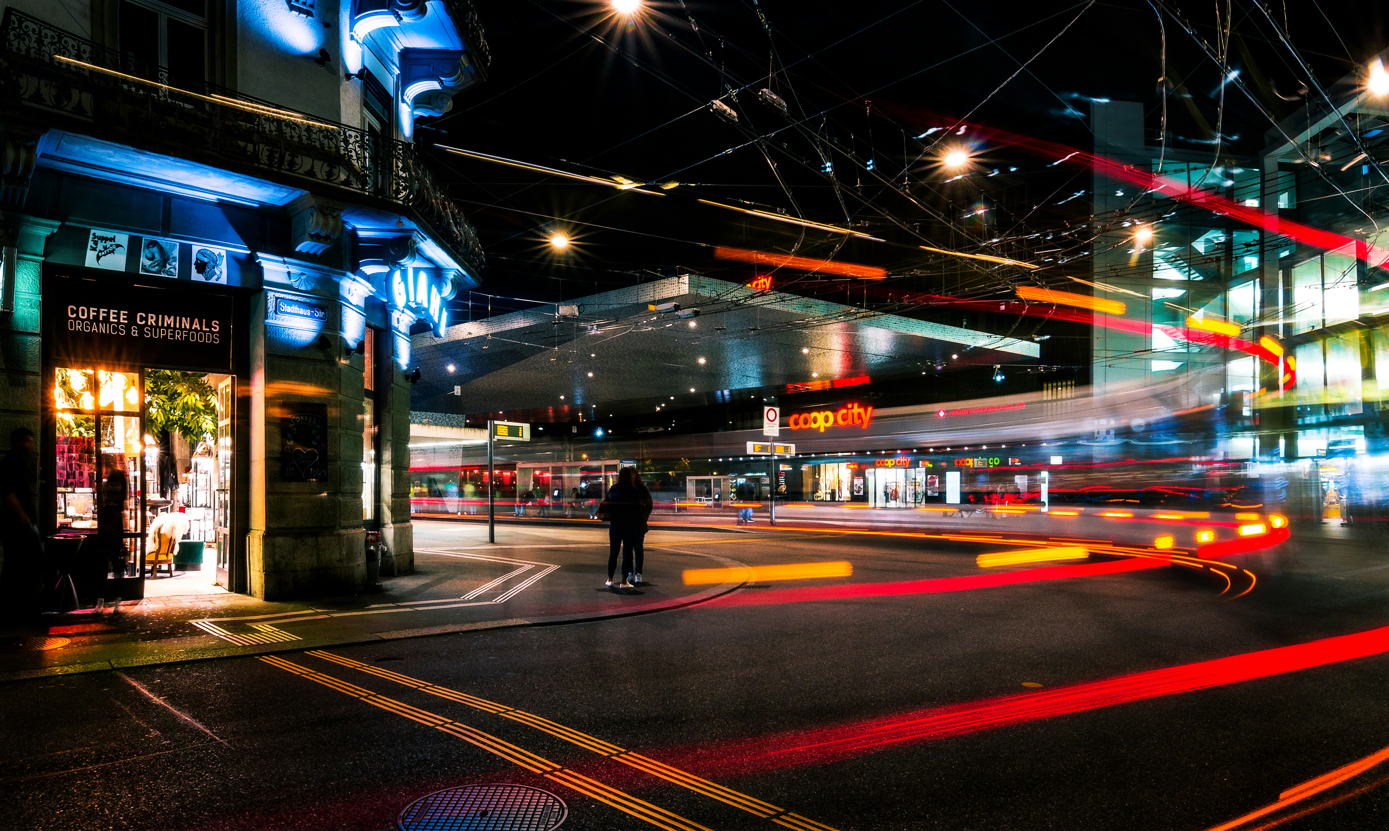 Una esquina de una calle con estela de luces de vehiculos en movimiento
