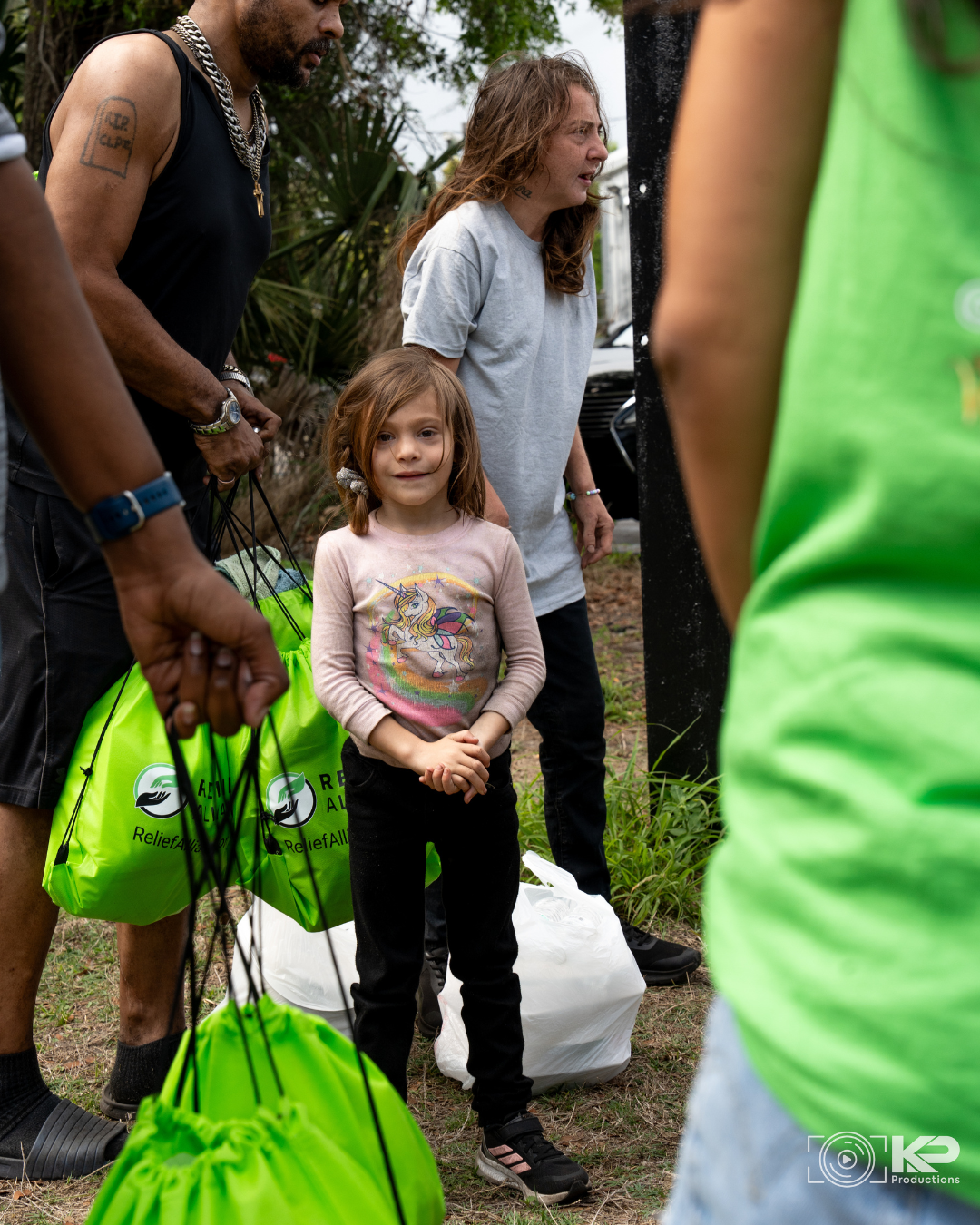 Relief Alliance volunteers providing food and essential supplies to a child during a homeless outreach in Orlando Florida
