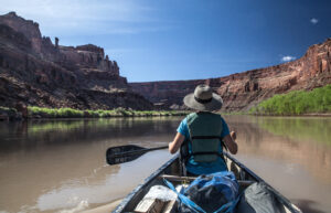 Woman paddling into the Labyrinth Canyon, Utah, USA