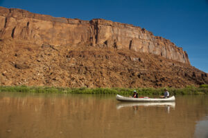 Mother and daughter canoeing on a calm blue river in the desert country of Utah