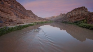 Tour guide narrating the history and geology of the canyon during the Sound and Light Show boat ride
