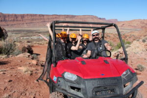 Group riding in UTV on red rock trail during Moab zipline adventure