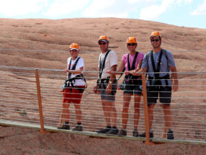 Guests crossing suspension bridge on Moab zipline course