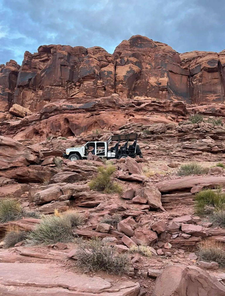 modified 4x4 traveling along Hurrah Pass trail beneath towering cliffs
