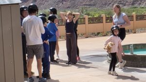 Group of riders of all ages putting on helmets before e-bike ride in Moab
