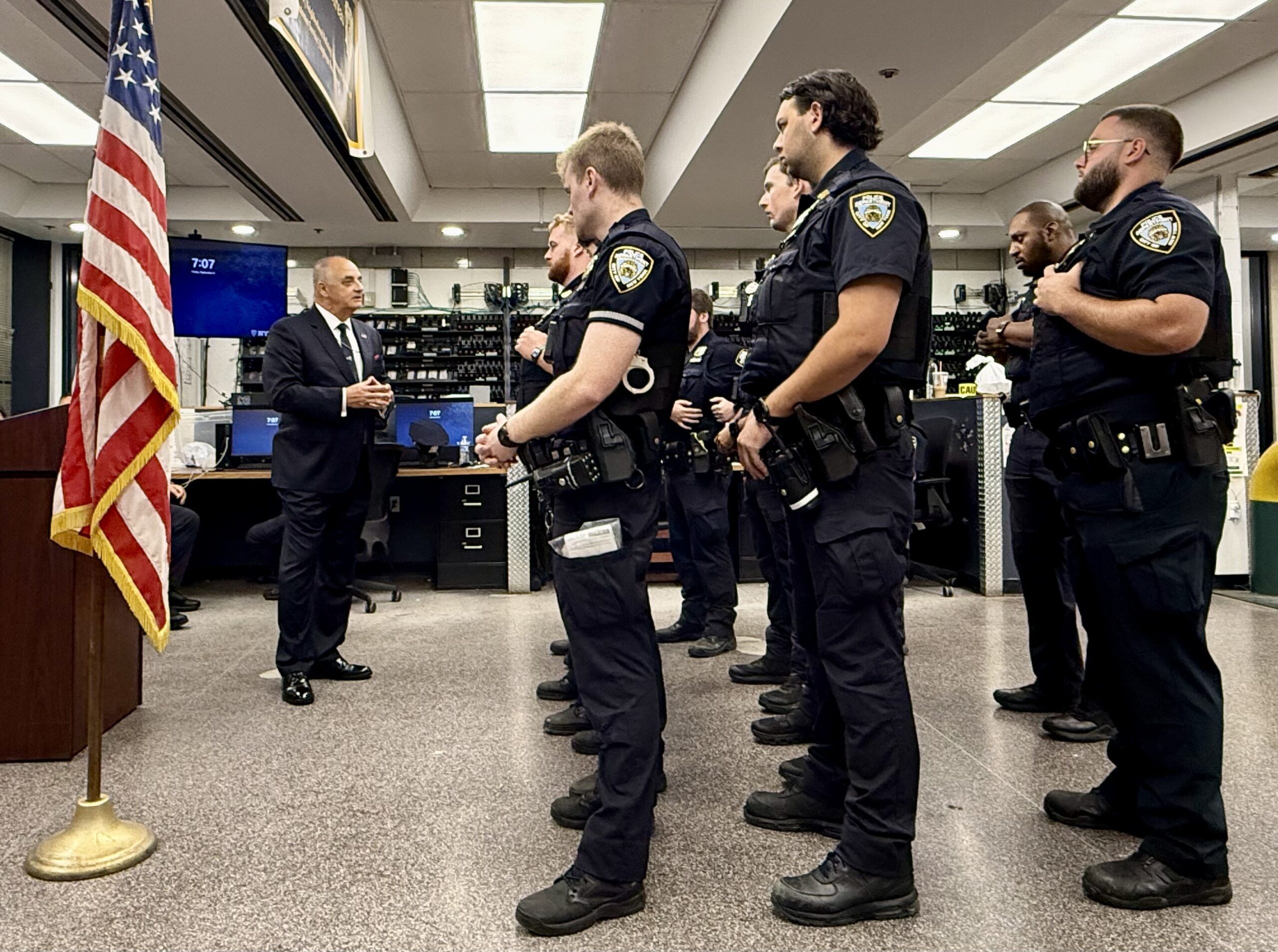 Vincent J. Bove addresses NYPD officers during a Midtown South Precinct roll call on September 4, 2026, with the American flag he personally brought into the muster room before the first roll call prominently displayed beside him.
Credit: NYPD Captain Benjamin M. Bellingeri for Reawakening America LLC