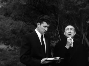 A video clip called gathered in silent prayer around the newly-opened grave...