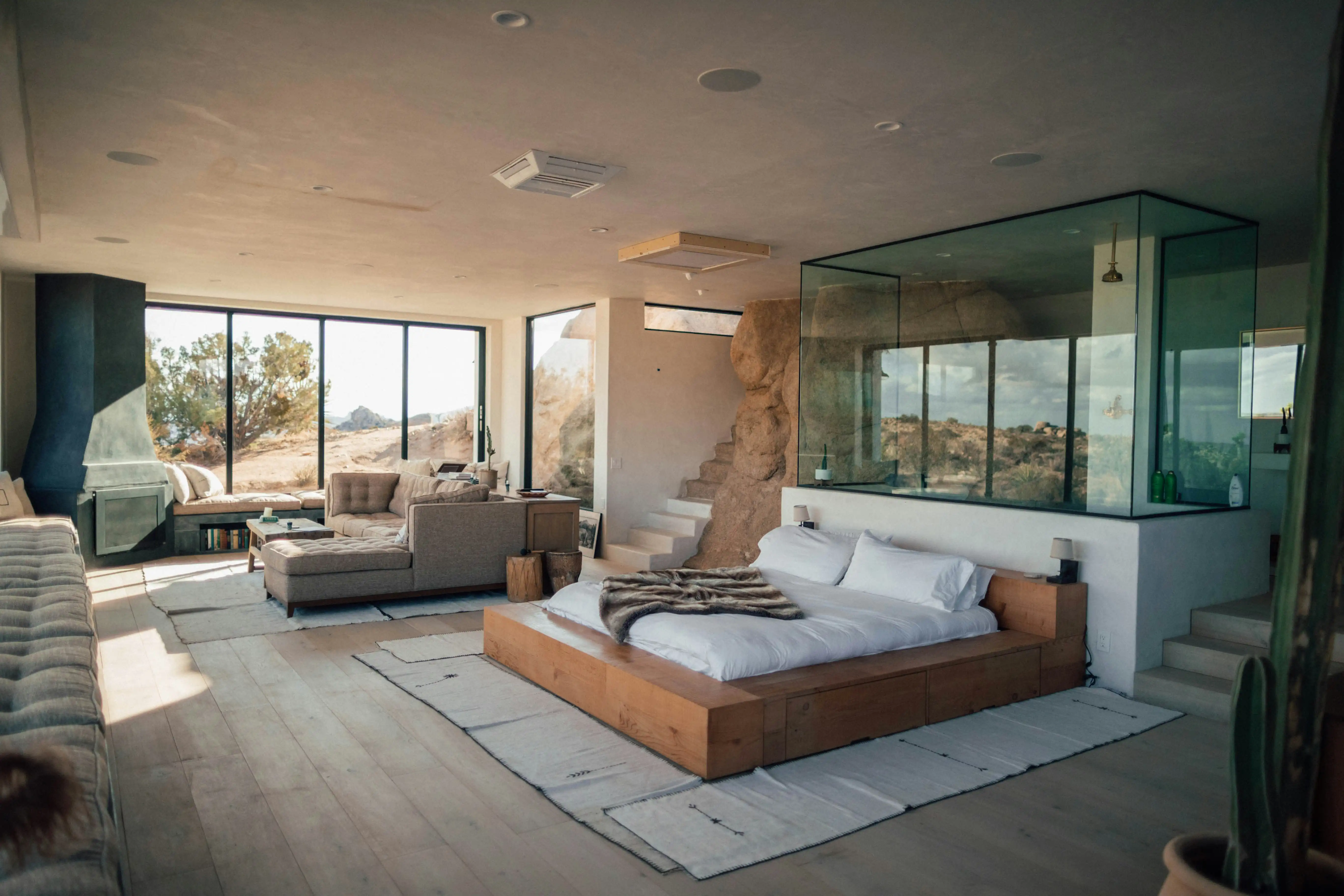 A luxury bedroom built into the rocky landscape, with large windows that showcase the natural world outside.