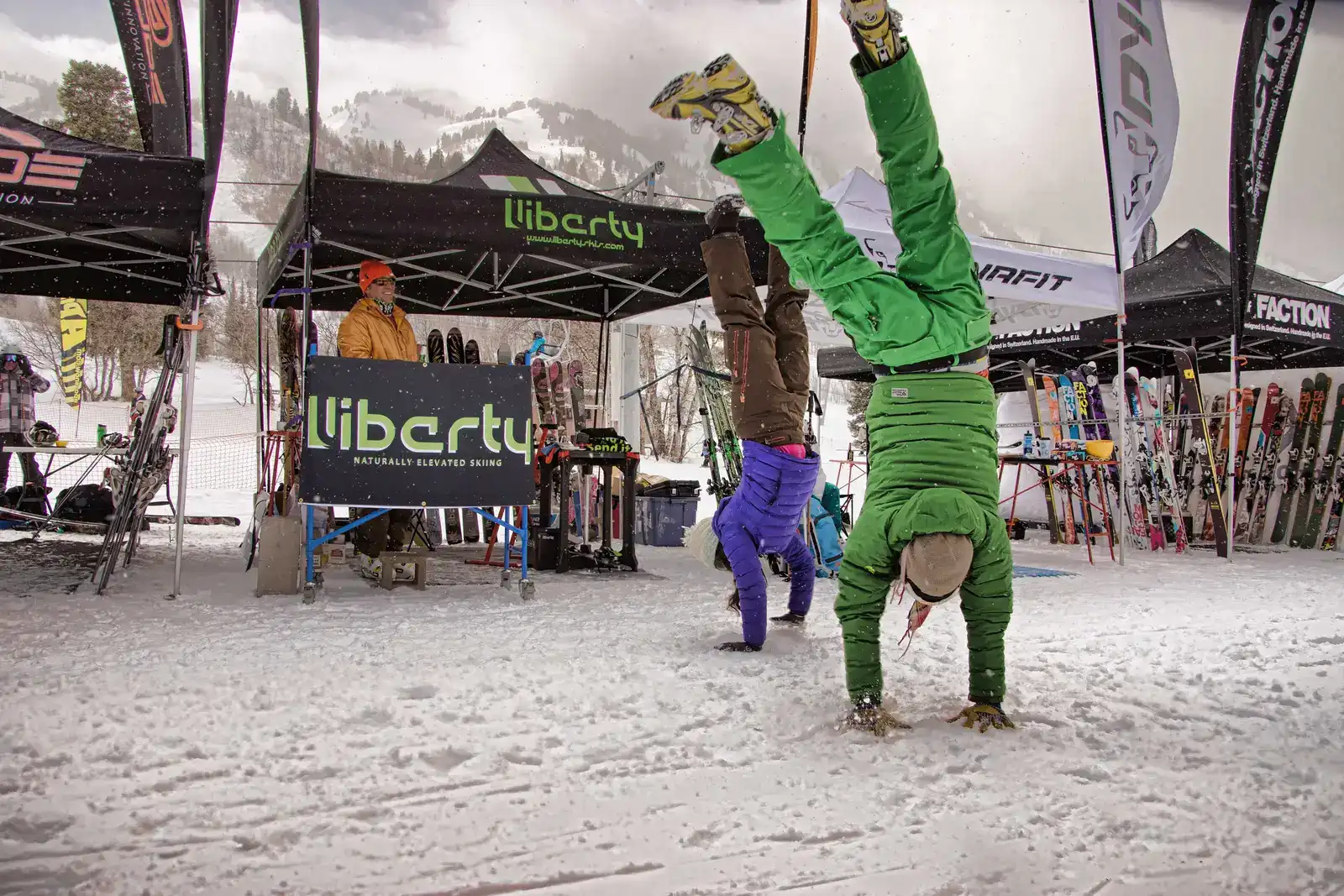 Skiers do hand stands at a ski resort event.