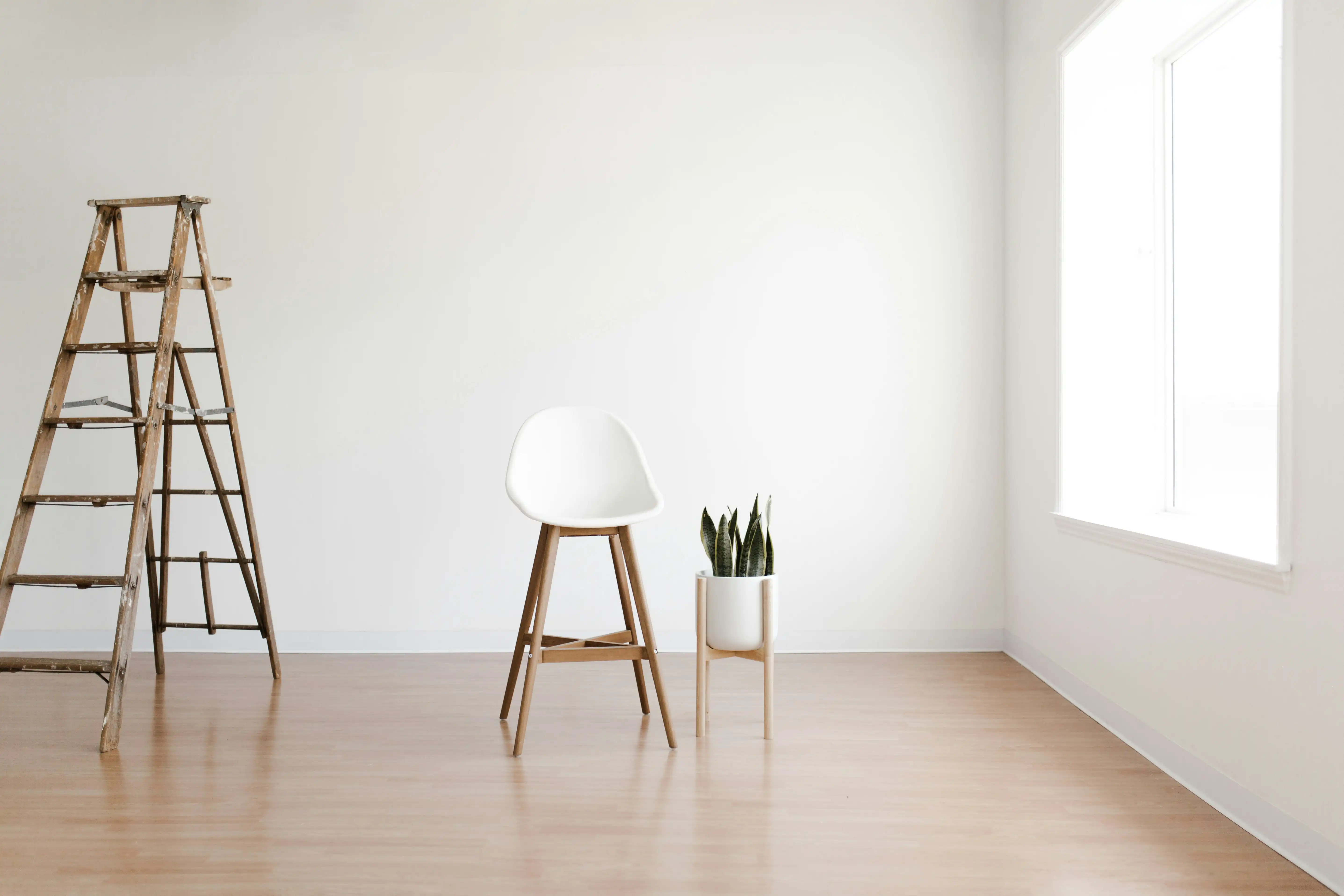 empty room with ladder, chair and plant