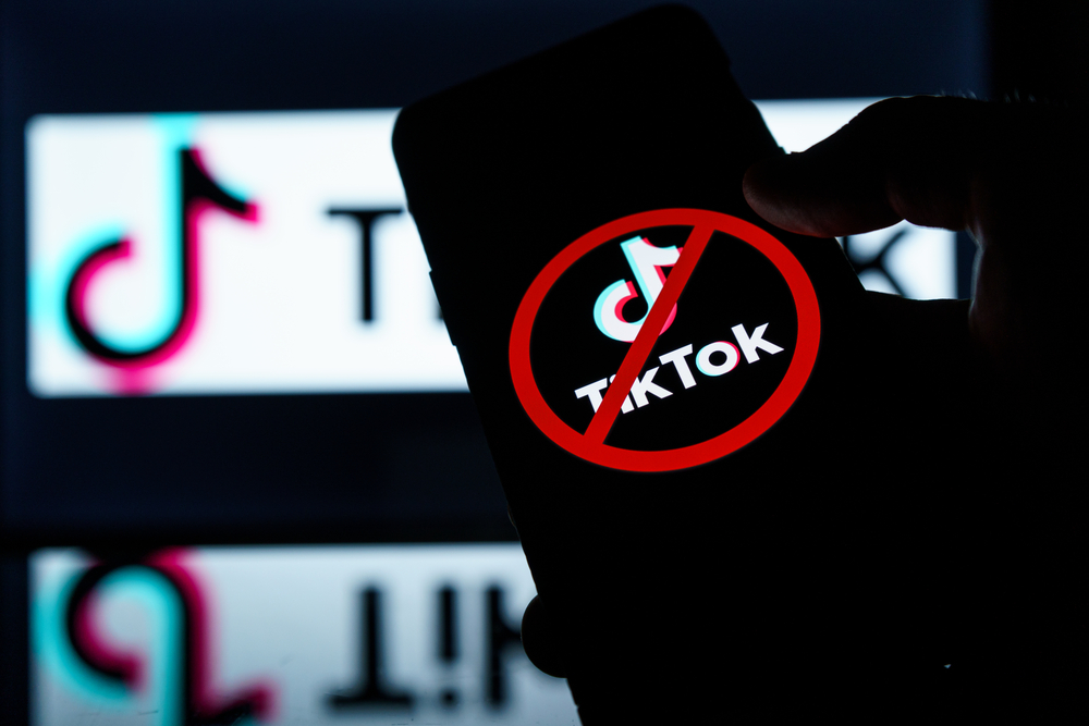 tiktok logo on screen with ban symbol on it. sanctions on tik tok app