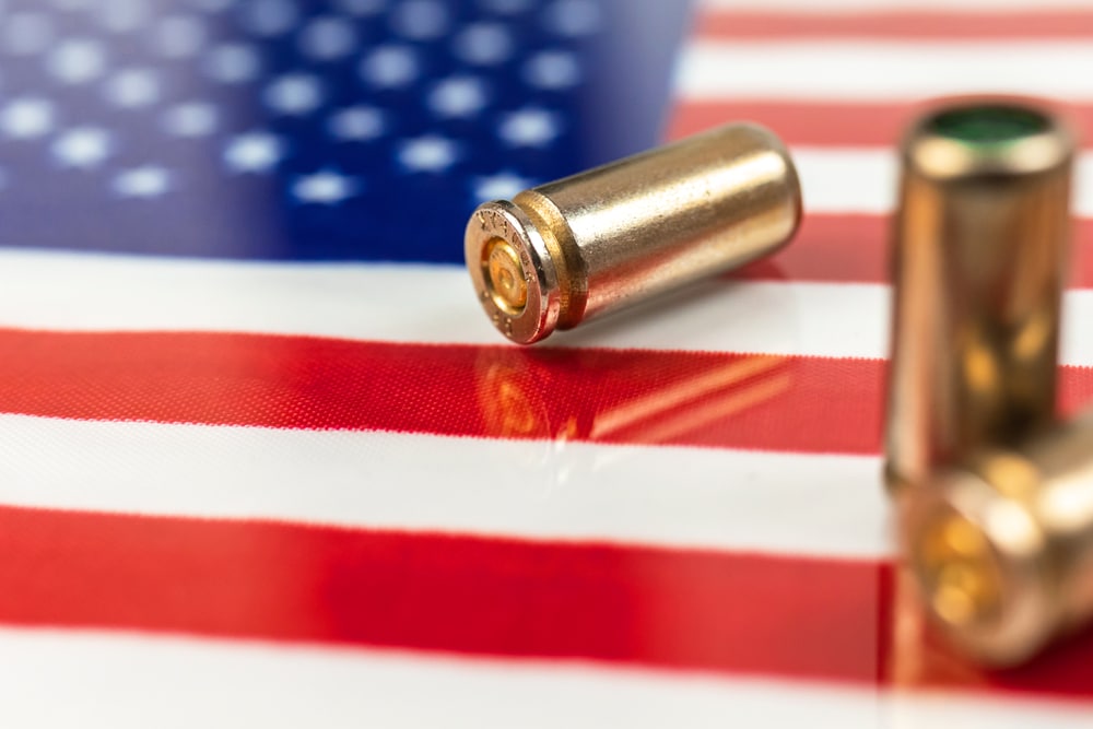 usa outlaw, ghetto, social problem and armed attack background. gun bullets over the american flag. criminal and corruption united states of america concept photo