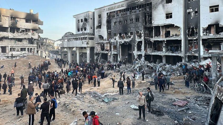 People gather outside the remains of Al-Shifa Hospital, Gaza's largest health facility. (WHO)