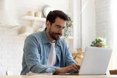 Man in blue shirt at laptop computer Man in blue shirt at laptop computer