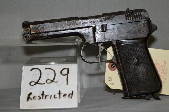 a very ugly, scratched and partially rusted pistol from world war two. The picture was taken at an auction (there are notes on papers next to the pistol). The pistol itself shows several markings such as the manufacturer's name "CZ" and a part of the serial number