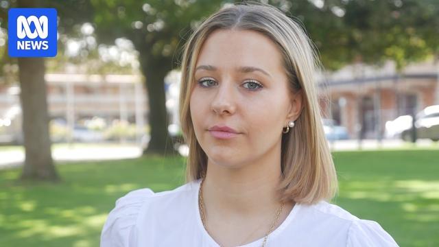 A young woman wearing right stares ahead with a sombre look.