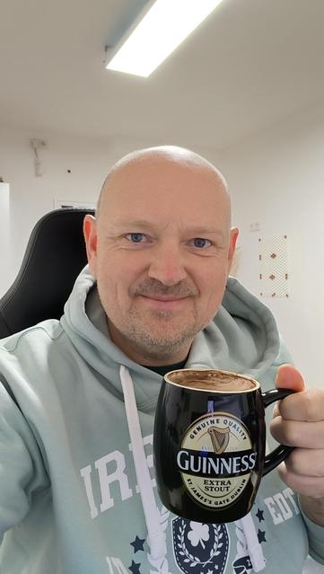 Selfie in my Homeoffice wearing a Ireland hoodie and holding a Guinness mug with coffee