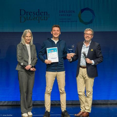 Artem Govorukhin (Mitte) während der Siegerehrung im Kleinen Haus des Staatsschauspiels Dresden zusammen mit den Jury-Mitgliedern Marion Schmidt und Prof. Gianaurelio Cuniberti von der TU Dresden.