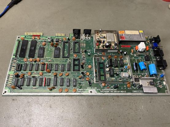 Commodore 64 Board on my workbench. It has some of the main ICs missing and several things look like previous repair attempts have been made.