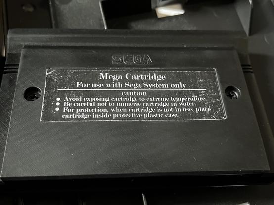 An image of a Sega Master System Cartridge with instructions for care and usage. The cartridge is labeled "Mega Cartridge" and specifies its compatibility with the Sega System. The caution section includes three bullet points regarding temperature, water exposure, and storage in a protective case