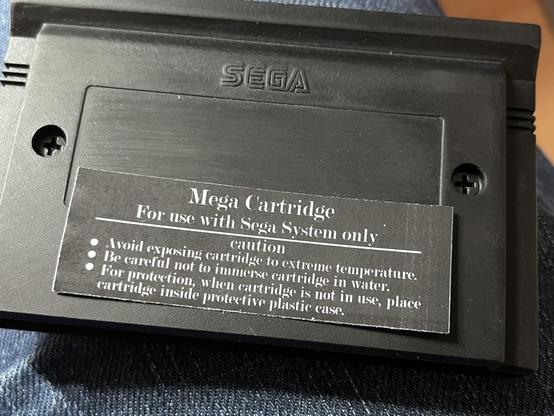 An image of the back of a Sega Master System cartridge. It features the Sega logo and a caution label with instructions on how to properly handle the cartridge, advising against exposure to extreme temperatures, immersion in water.  The label isn’t affixed