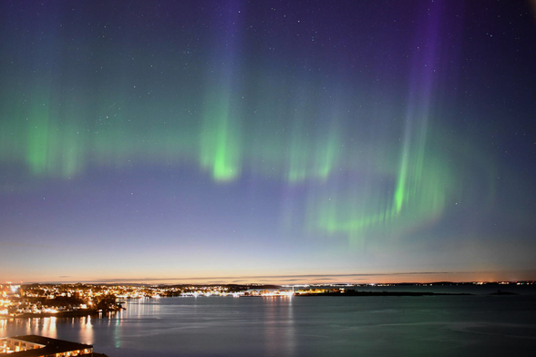 Picture of the aurora, taken from a camera set up by the air ambulance service. Arcs of green and purple reach into the skies and has a "wave" pattern to it