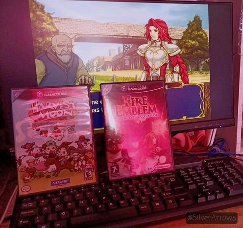Playing Fire Emblem Path of Radiance on my PC. Cases for the discs for both Harvest Moon Magical Melody and Path of Radiance lean against the monitor.