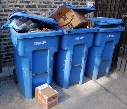 Row of three blue overstuffed recycling cans