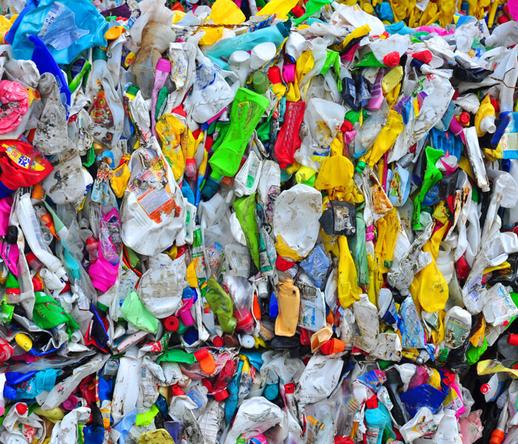 Photo shows a bale of plastic polyethylene bottles crunched into a bale and awaiting recycling.
