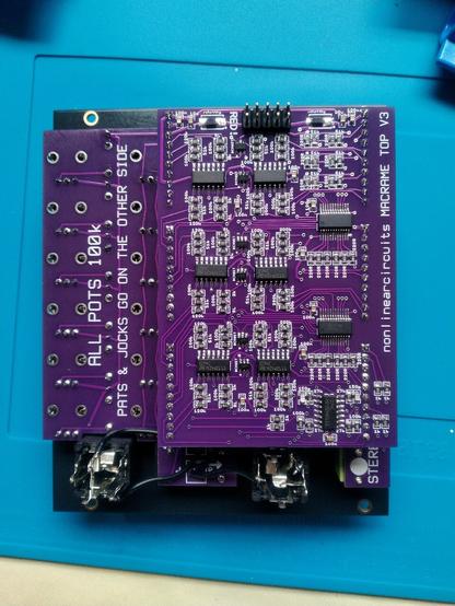 The rear of a eurorack mixer module.
The PCBs are purple and populated with surface mount components - resistors, capacitors, diodes and ICs.