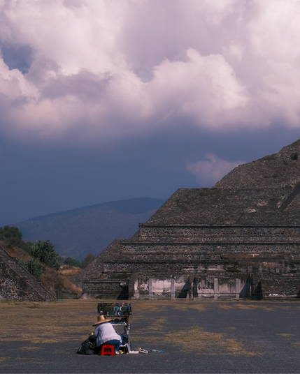 Artice Local artisen sitting on a red chair infront Pyramid of the Moon, mexico.