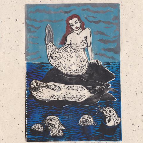 My linocut on speckled cream coloured washi paper of a selkie shedding her sealskin and several harbour seals lounging on rocks or swimming on a cloudy day.