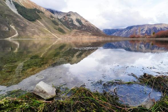 Lake Pearson, also known as Moana Rua, is a picturesque high-country lake nestled in the Craigieburn Forest Park of New Zealand's South Island. Located approximately 125 km west of Christchurch along State Highway 73, the lake is easily accessible and offers a tranquil retreat amidst the Southern Alps. The lake's distinctive hourglass shape is flanked by rugged limestone boulders, creating a striking contrast against the surrounding alpine scenery. Spanning about 195 hectares, Lake Pearson is renowned for its clear waters and is a popular spot for fishing, particularly for brown trout, as well as birdwatching, with sightings of native species such as the New Zealand scaup and black swan. Visitors can enjoy various activities including kayaking, paddleboarding, and hiking, with trails like the one leading to Purple Hill offering panoramic views of the area. The nearby Moana Rua Campsite provides a semi-alpine camping experience, accommodating up to 20 tents, and serves as a convenient base for exploring the region. Whether you're seeking outdoor adventure or a peaceful natural setting, Lake Pearson offers a memorable experience in one of New Zealand's most scenic locales.