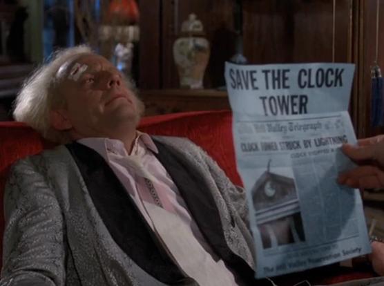 Doc Brown holding the “Save The Clock Tower” flyer from Back To The Future.