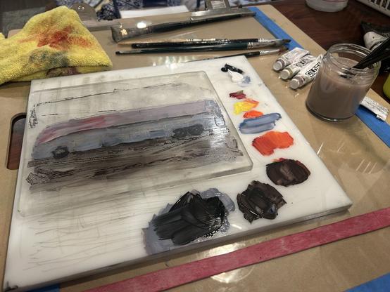 The bus windows filled in and backed up, same for ground shadow and wheels. The gelli plate is on my usual palette which is a white plastic slab. Colored acrylic paint on the right margins of the palette. All this is on the glass taped to my drawing board.