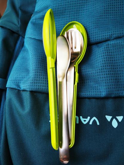 Besteckset mit aufgeklappter Hülle, liegt auf einem Rucksack