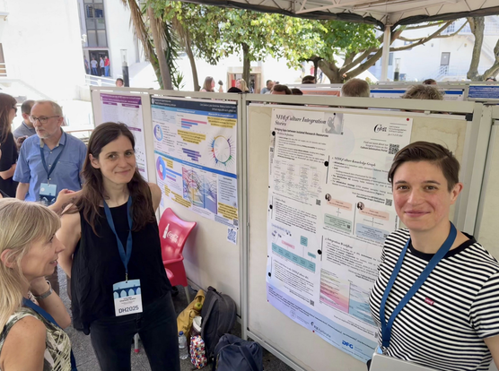 Linnea (left) and Tabea (right) standing in front of their poster at the DH2025 conference in Lisbon, Portugal