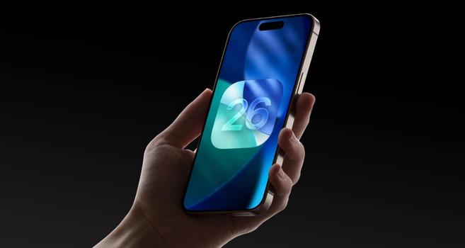 Eine Hand hält ein iPhone in die Höhe, auf dem ein blaugrünes Wallpaper mit dem iOS 26-Icon zu sehen ist. Der Hintergrund ist schwarz.
