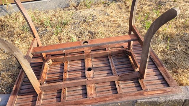 Old teak? furniture on the side of the road, upside down