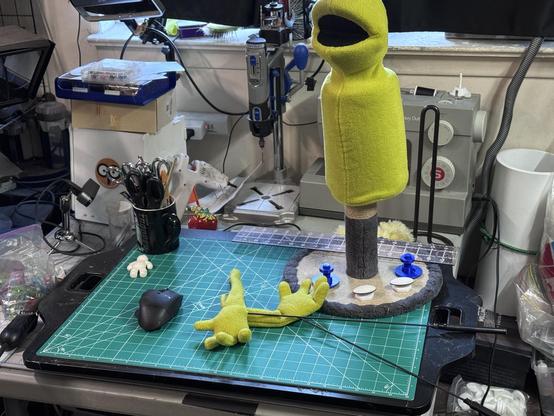 Kevin’s work table with a green cutting mat and partially constructed human puppet