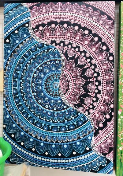 a painting, it is a cropped mandala, a wavy line running diagonally through it, half of it is done in blue and the other side is pink