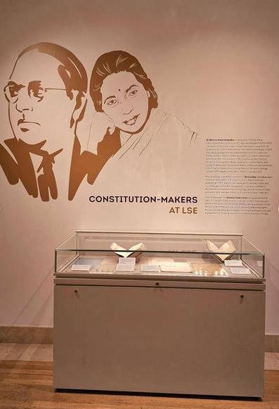 A photograph taken by LSE South Asia Centre of a section of the exhibition at SOAS. You can see on the wall a drawing of profiles of Ambedkar  and Renuka Ray. There is some text that reads "Constitution-Makers at LSE) and a table top displaying some documents.
