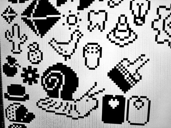 a black and white sheet of pixelly icons resembling tattoo flash. a large snail, traffic cone, hats, a bird, tooth, paint brush and bread tag all feature.