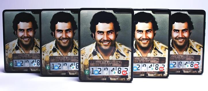 Fünf aufgeklappte Escobar Fold-Smartphones stehen nebeneinander und zeigen jeweils den Mugshot von Pablo Escobar auf dem Bildschirm an. Foto (c) Escobar Inc.