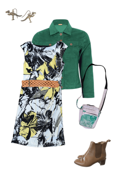 Flat lay of a femme outfit featuring a floral print dress in yellow, black, and pale blue, cinched with a tan woven belt. Paired with a green corduroy jacket, tan ankle boots, and a small crossbody bag with a green and white fish print. Accessories include gold dinosaur earrings.
