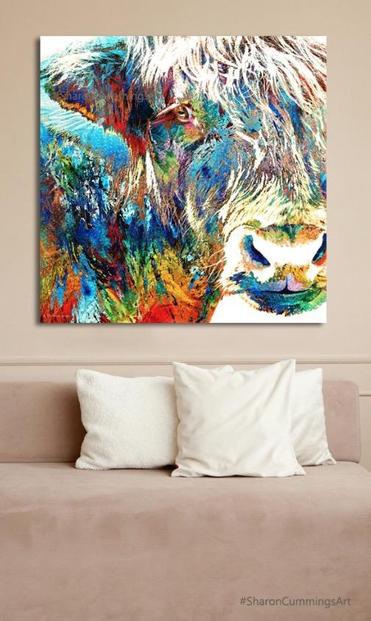 Colorful Highland Cow over a sofa with pillows by artist Sharon Cummings.